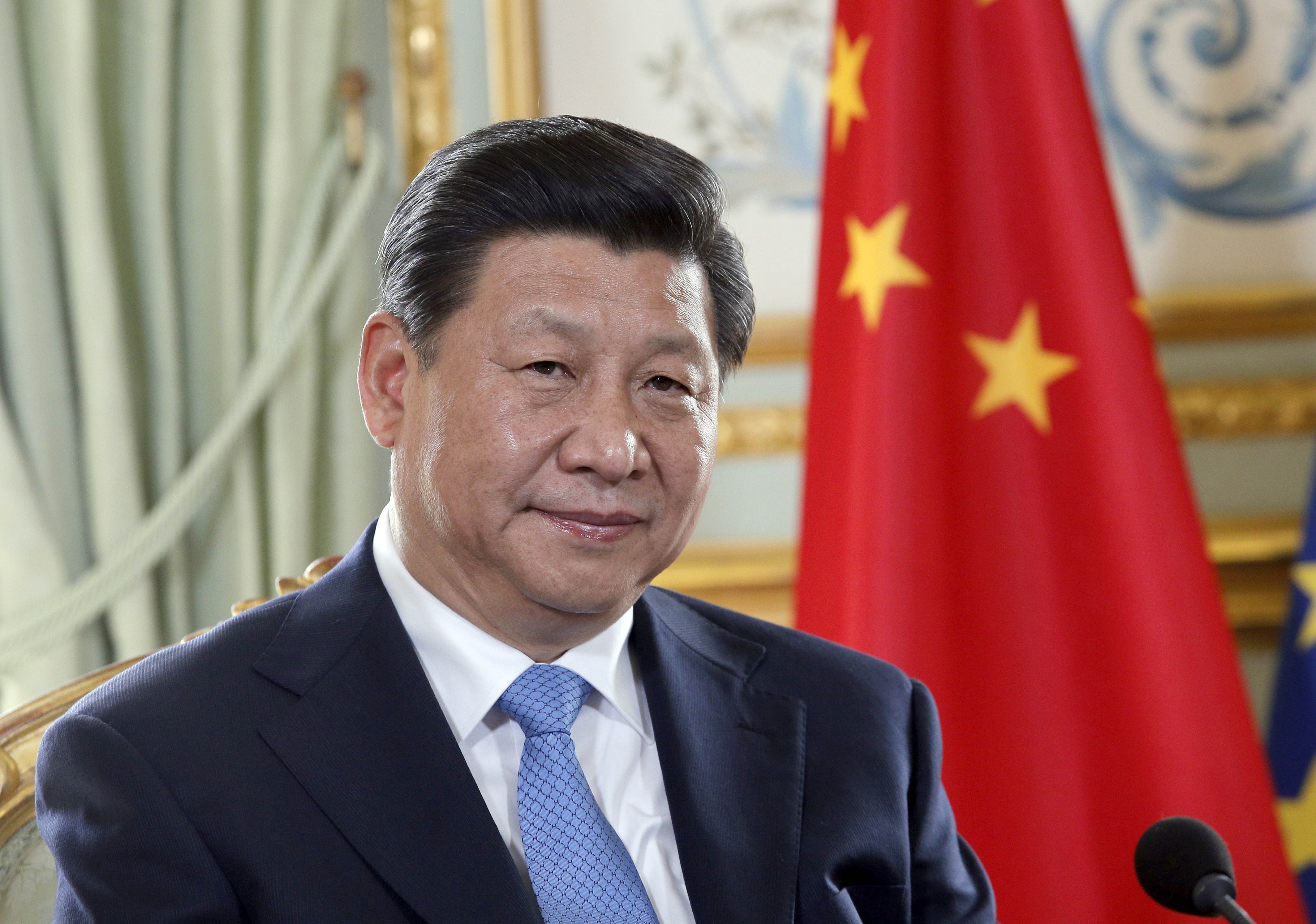 Il presidente cinese xi jinping in posa davanti alla bandiera cinese