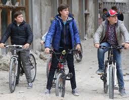 Tre ragazzi girano in bici tra le macerie de L'Aquila. Una scena tratta dalla serie 'L'Aquila, Grandi speranze'