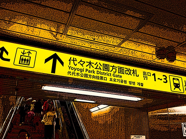 Immagine dell'interno di una stazione (Per leggerne la descrizione proseguire nel link) Le scale mobili e l'insegna per le uscite (giapponese e inglese).