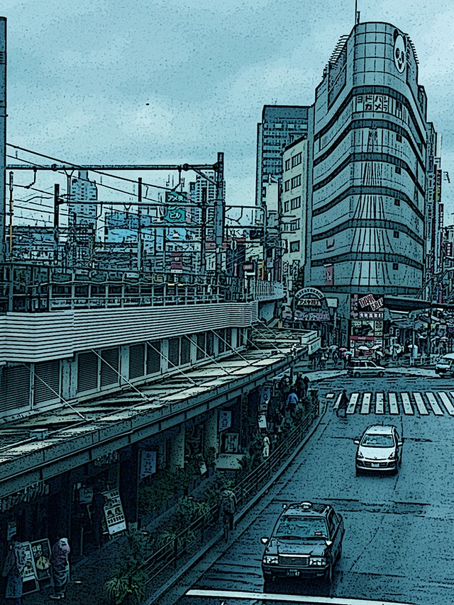 Immagine esterna di una stazione di Tokyo (Per leggerne la descrizione proseguire nel link). La linea ferroviaria sopraelevata e un moderno edificio nell'angolo di un incrocio.
