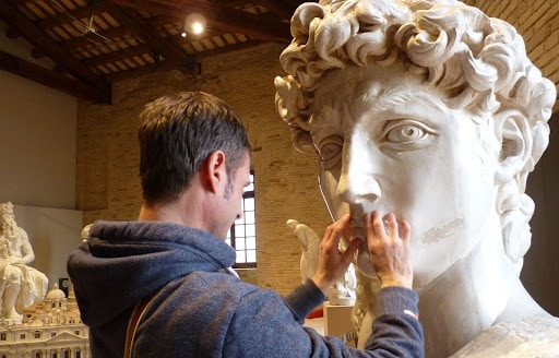 Un uomo esplora col tatto una scultura al Museo Omero Un uomo esplora col tatto una scultura al Museo Omero